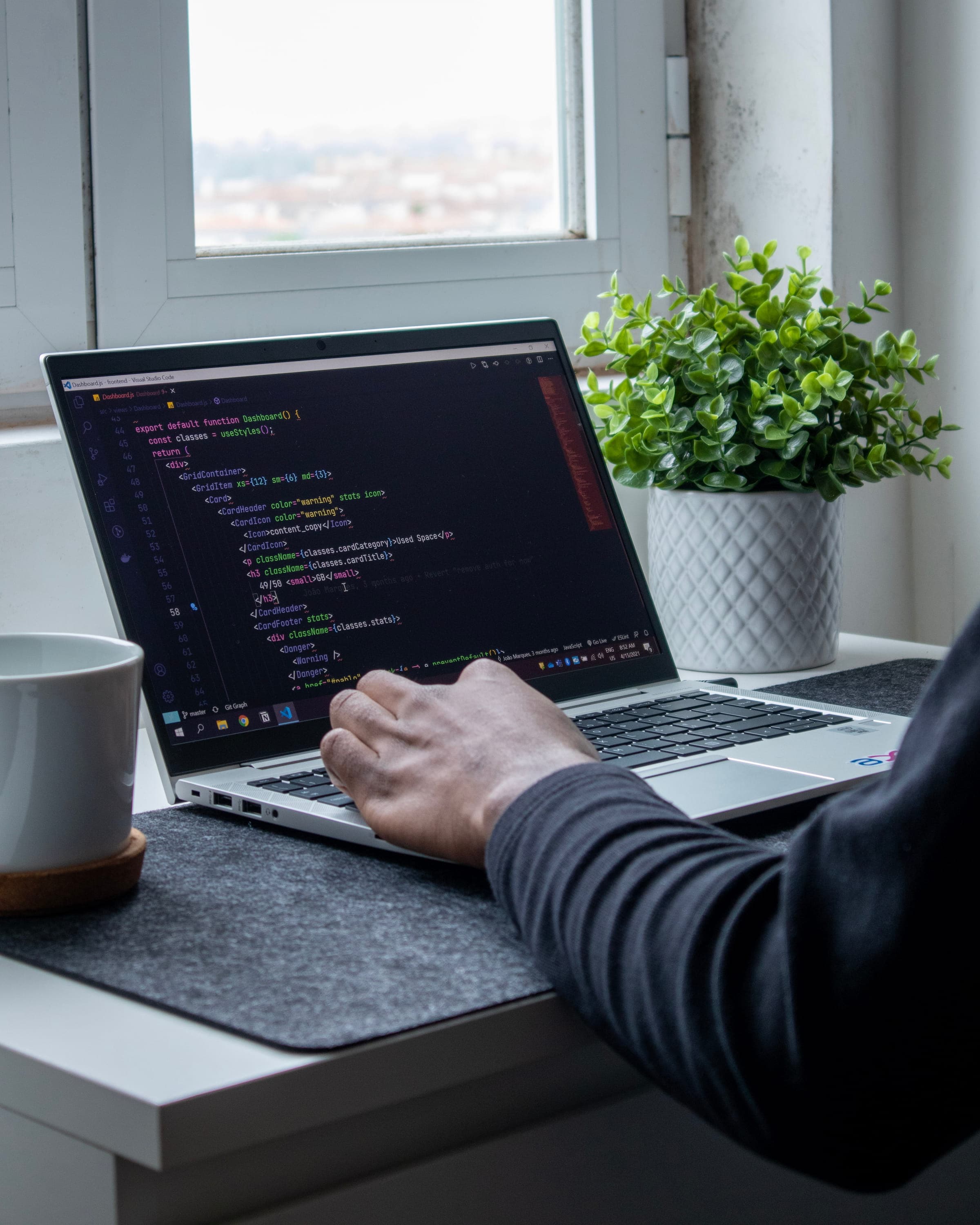 Een foto van iemand die software ontwikkelt achter een laptop.